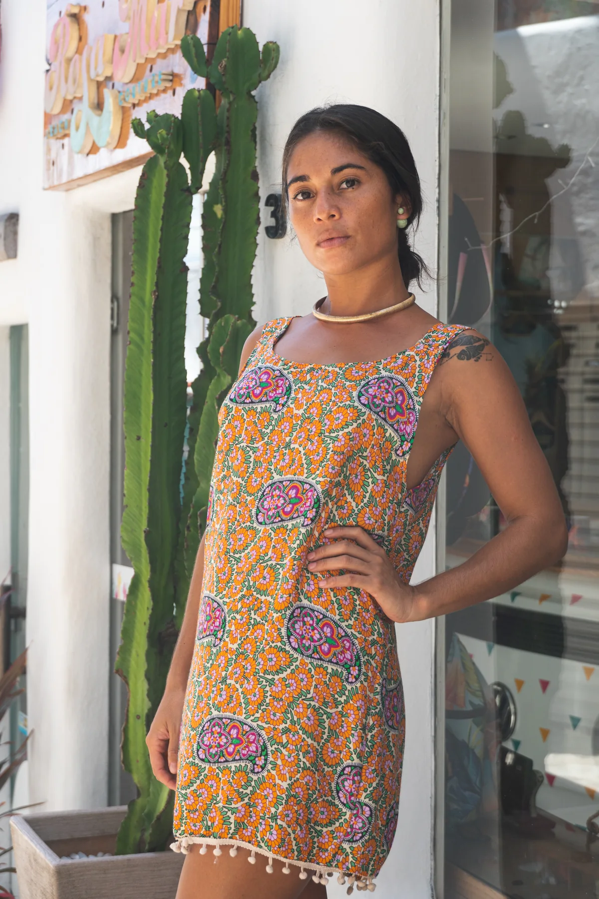 Retrato editorial con vestido estampado junto a cactus