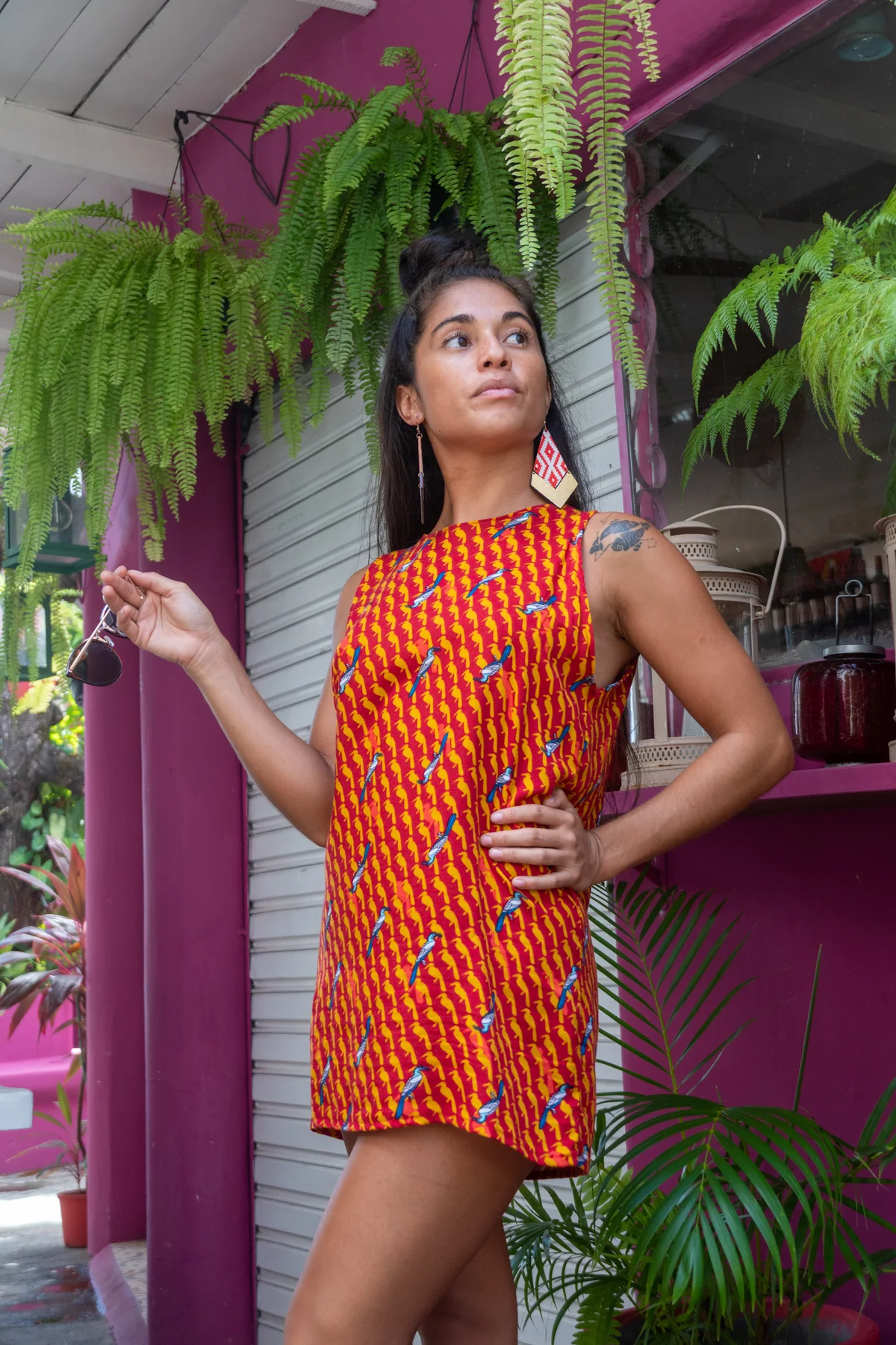 Retrato de cuerpo completo con vestido rojo frente a pared fucsia