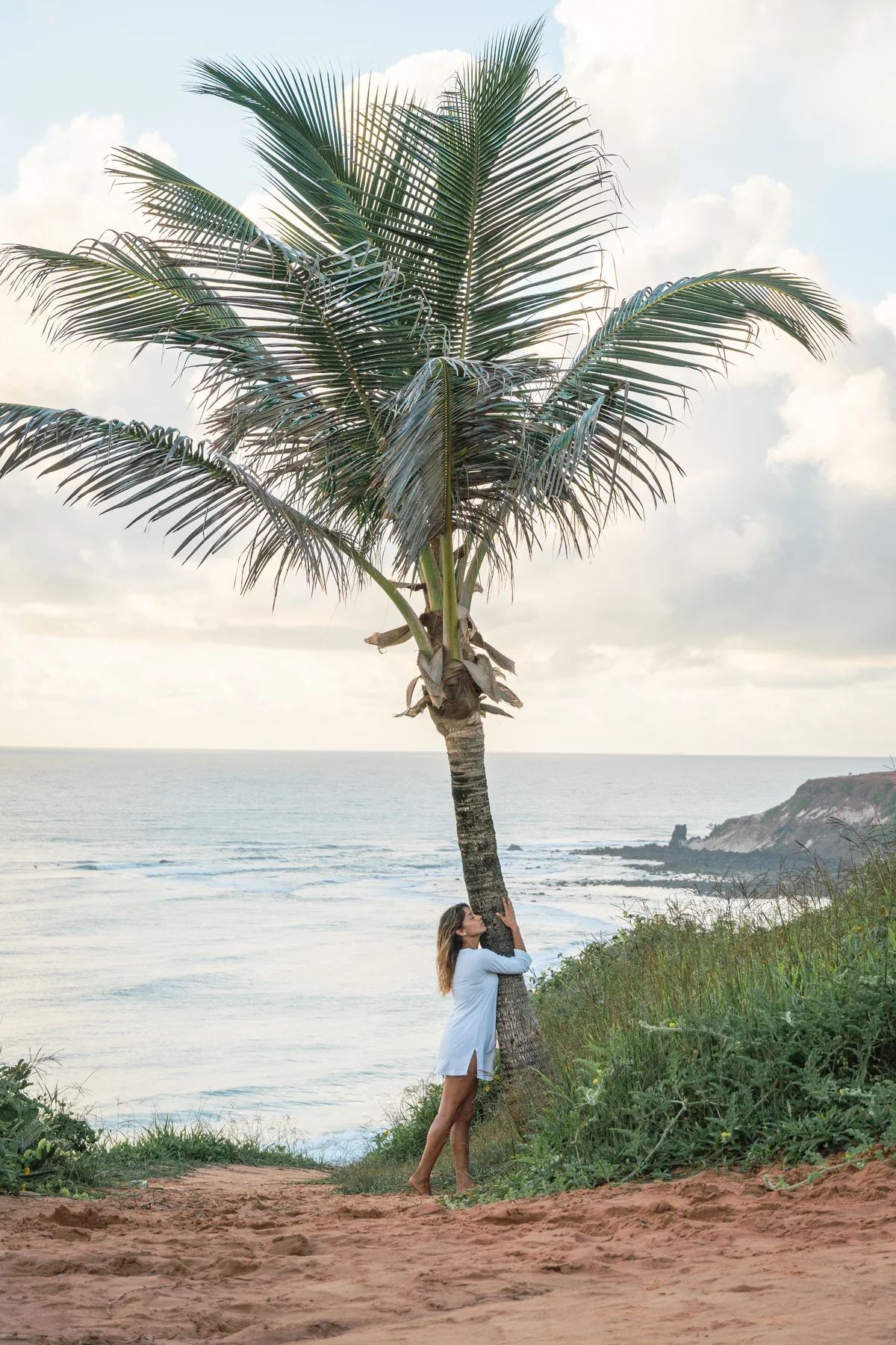 Retrato junto a palmera con vista amplia al océano